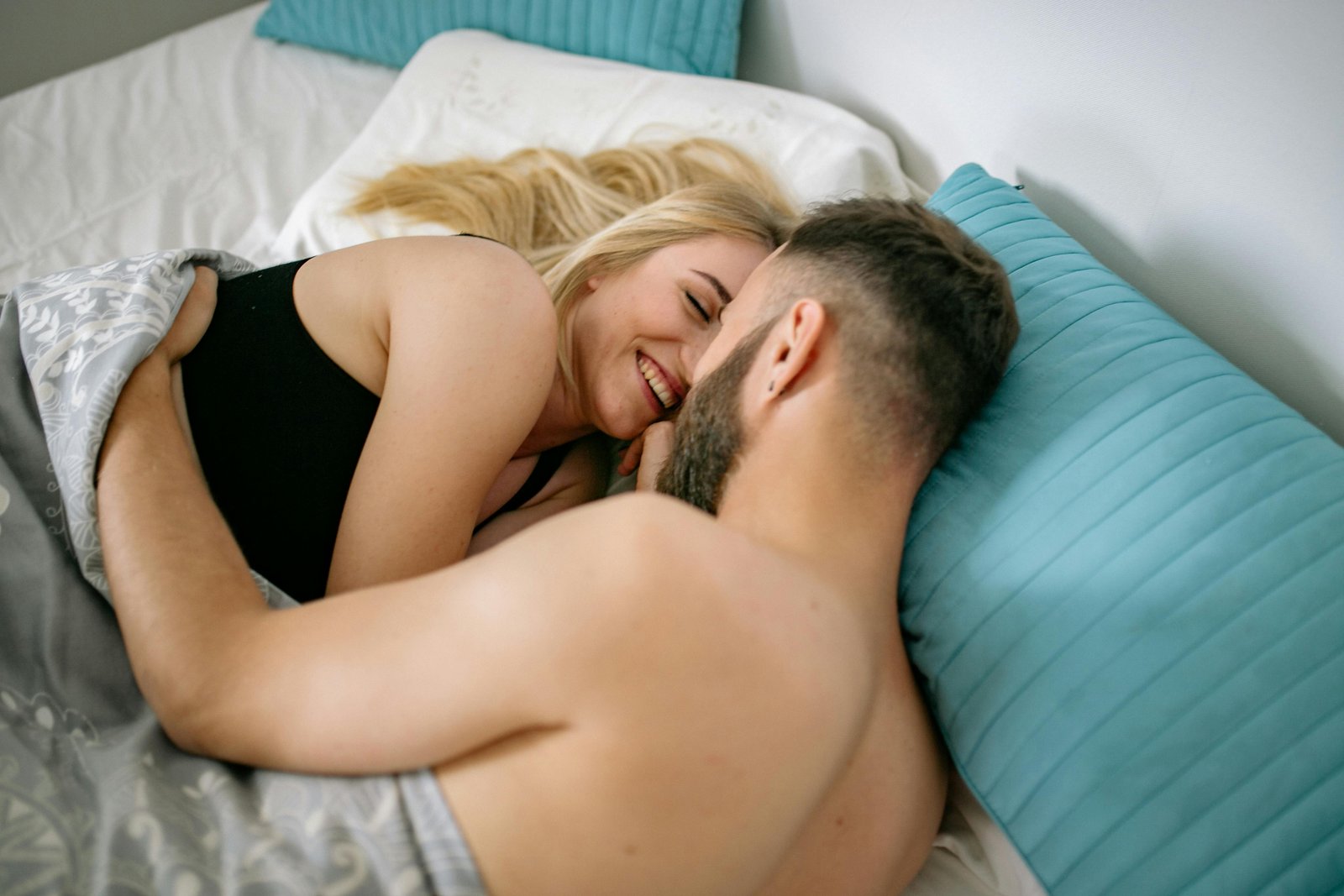 Uomo e donna che si coccolano a letto come programma di benessere